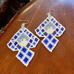 Pair of handwoven bead earrings with bird in a blue and white geometric pattern